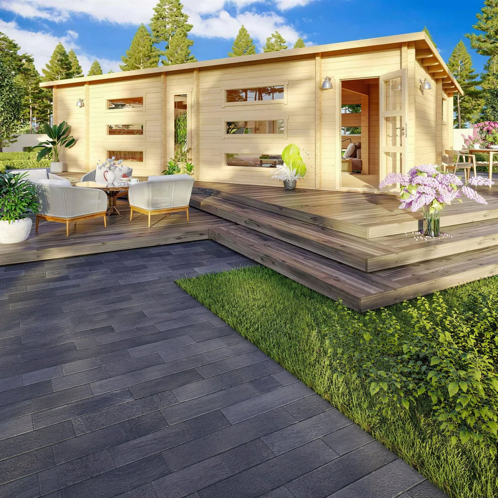 Surrounded by flowers and trees, the GardenHouse24 USA Dundee 90A Garden Room features a spacious deck, modern seating, and double glass doors