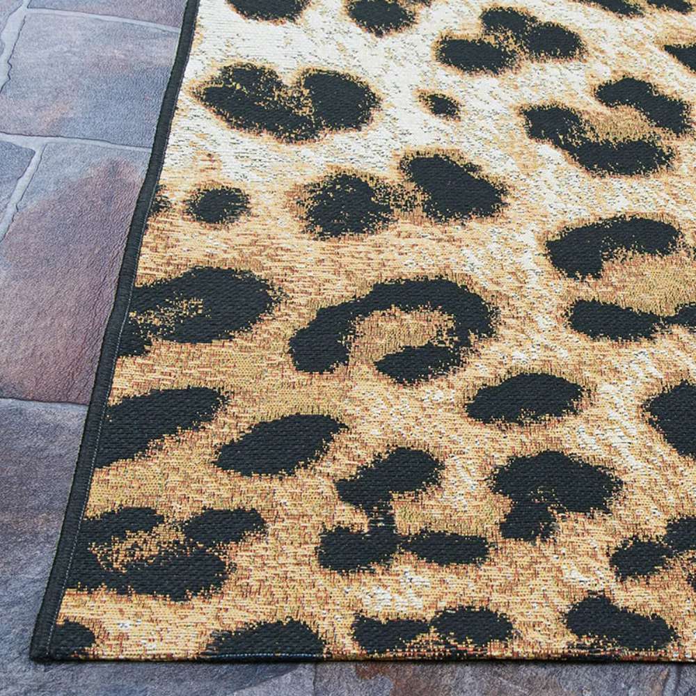 Edge of Couristan Dolce Indoor/Outdoor Rug - Amur Leopard/New Gold is shown laid on stone flooring