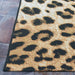 Edge of Couristan Dolce Indoor/Outdoor Rug - Amur Leopard/New Gold is shown laid on stone flooring