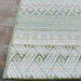 Edge of the Couristan Cape Indoor/Outdoor Rug - Gables/Palm is shown flat on stone flooring, displaying its clean, symmetrical lines and pattern transitions