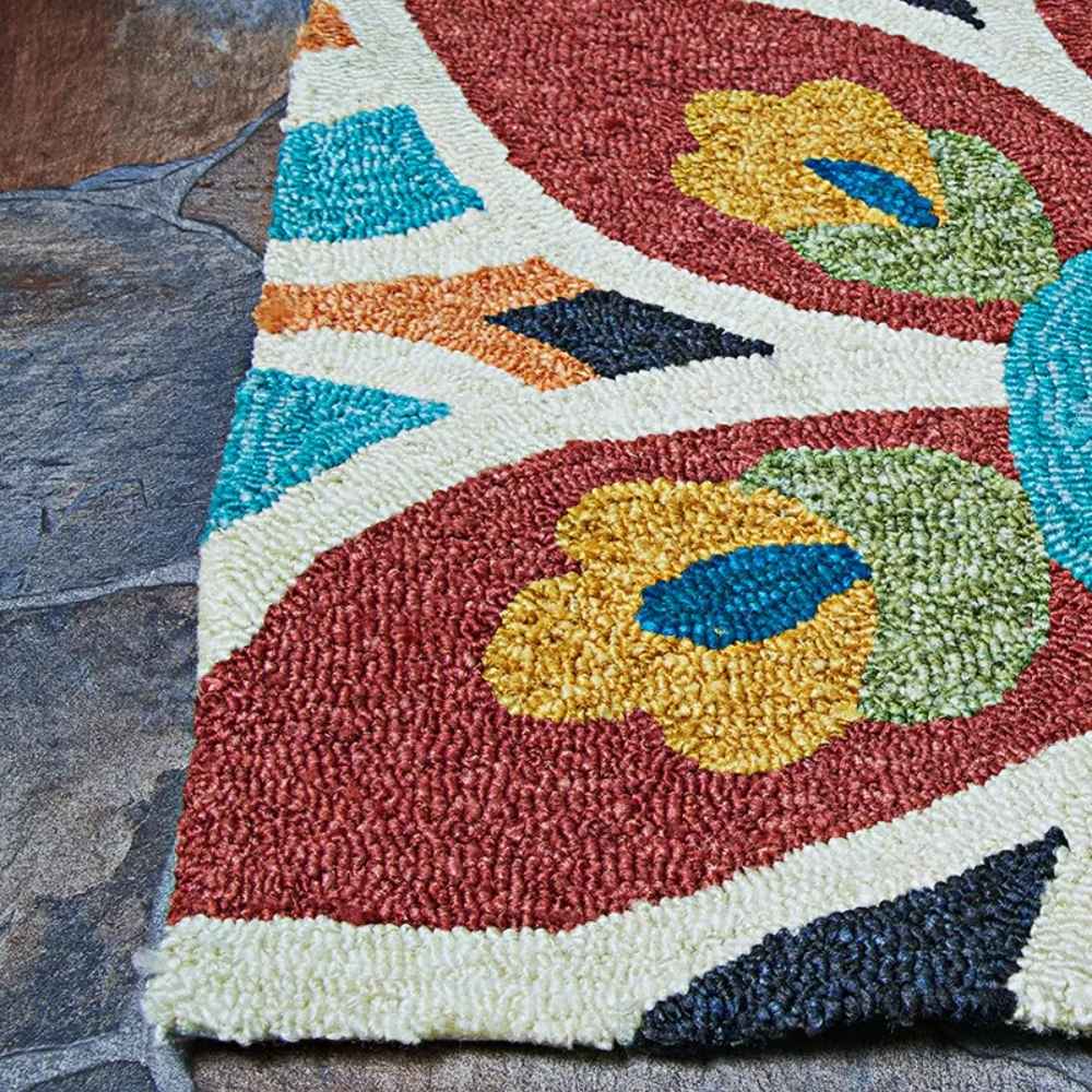 Edge of the Couristan Covington Indoor/Outdoor Rug - Geranium/Navy-Multi shows detailed loops and bold colors resting on a stone floor