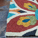 Edge of the Couristan Covington Indoor/Outdoor Rug - Geranium/Navy-Multi shows detailed loops and bold colors resting on a stone floor