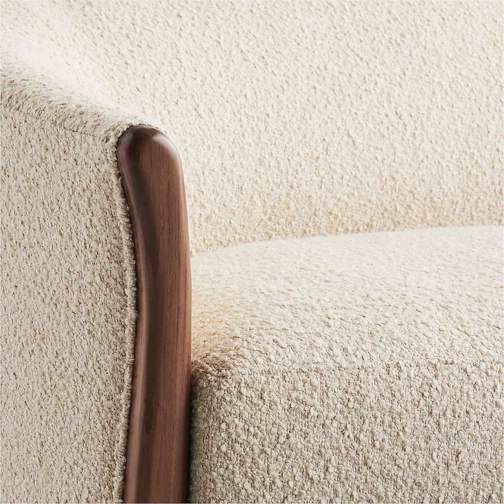 Fabric Tapioca (Lucie Boucle) Crate & Barrel Contour Sofa close-up showing the soft boucle fabric and curved walnut wood arm detail