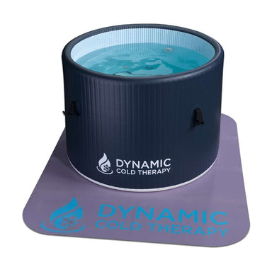 Filled with clear blue water, Golden Designs Dynamic Cold Therapy Inflatable Round Cold Plunge stands on a lavender floor mat printed with the Dynamic Cold Therapy logo