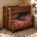 Fireside Lodge Barnwood Bunk Bed shown as a rustic wooden bunk bed with a left-side ladder and two stacked beds dressed in patterned bedding