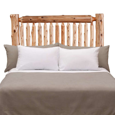 Fireside Lodge Cedar Log Small Spindle Headboard shown fully assembled on a bed, featuring rustic cedar logs, vertical spindles, and a natural lodge-style design