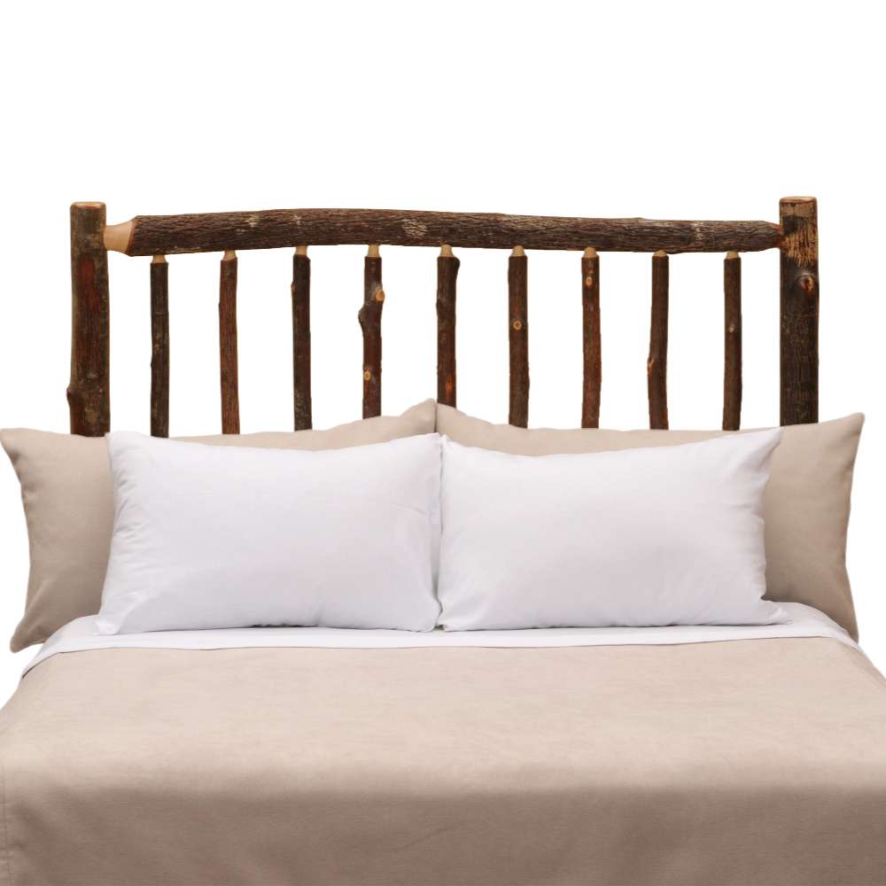Fireside Lodge Hickory Log Traditional Headboard shown as a rustic headboard made from natural hickory logs with visible knots behind neatly arranged pillows