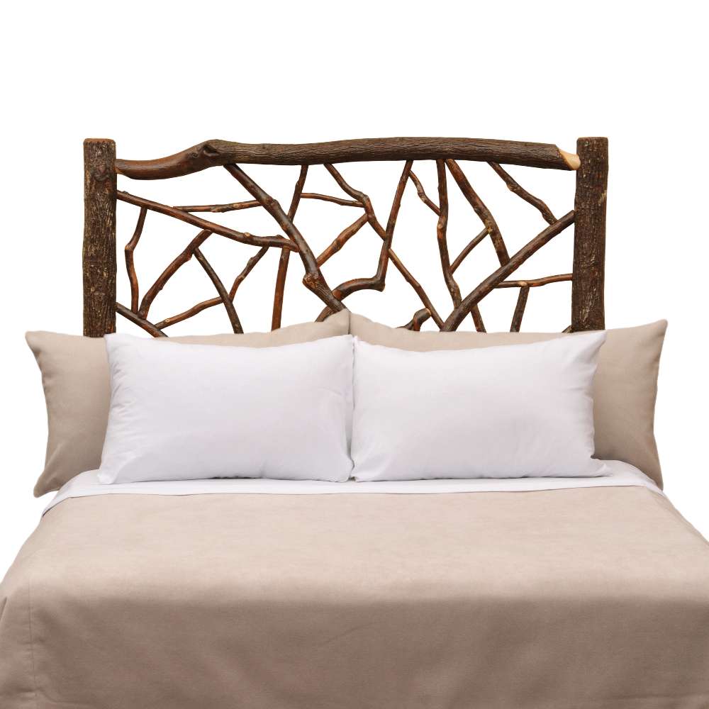 Fireside Lodge Hickory Log Twig Headboard features a rustic log frame with intertwined twig details behind a bed with light neutral bedding