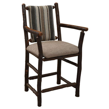 Fireside Lodge Hickory Log Upholstered Counter Stool with Arms is a rustic hickory log counter stool with armrests, a cushioned tan seat, and a striped fabric backrest in earthy tones