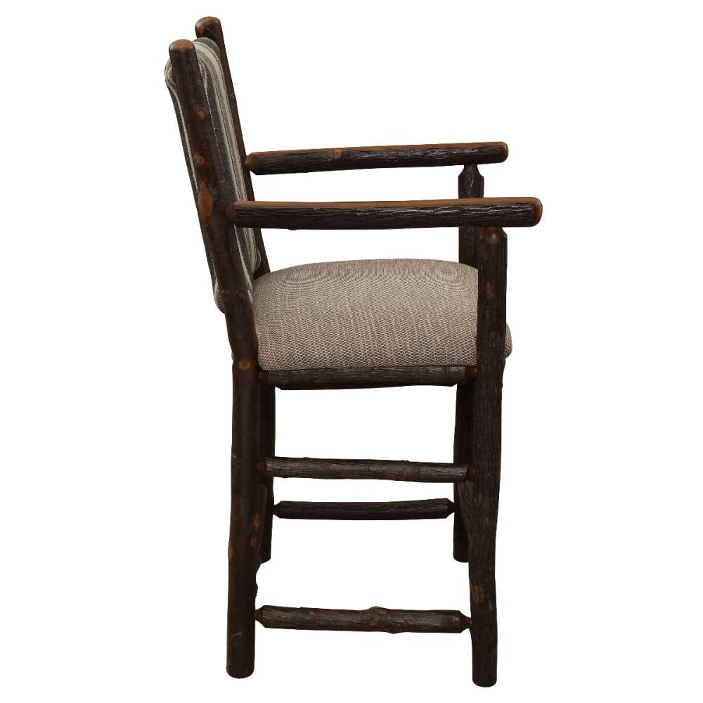 Fireside Lodge Hickory Log Upholstered Counter Stool with Arms shows a sturdy hickory log base with stretchers, smooth armrests, and a comfortable padded seat and backrest