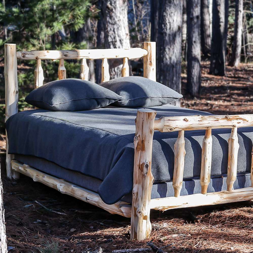 Fireside Lodge Voyageur Traditional Bed - Unassembled is shown fully assembled outdoors with a mattress and pillows