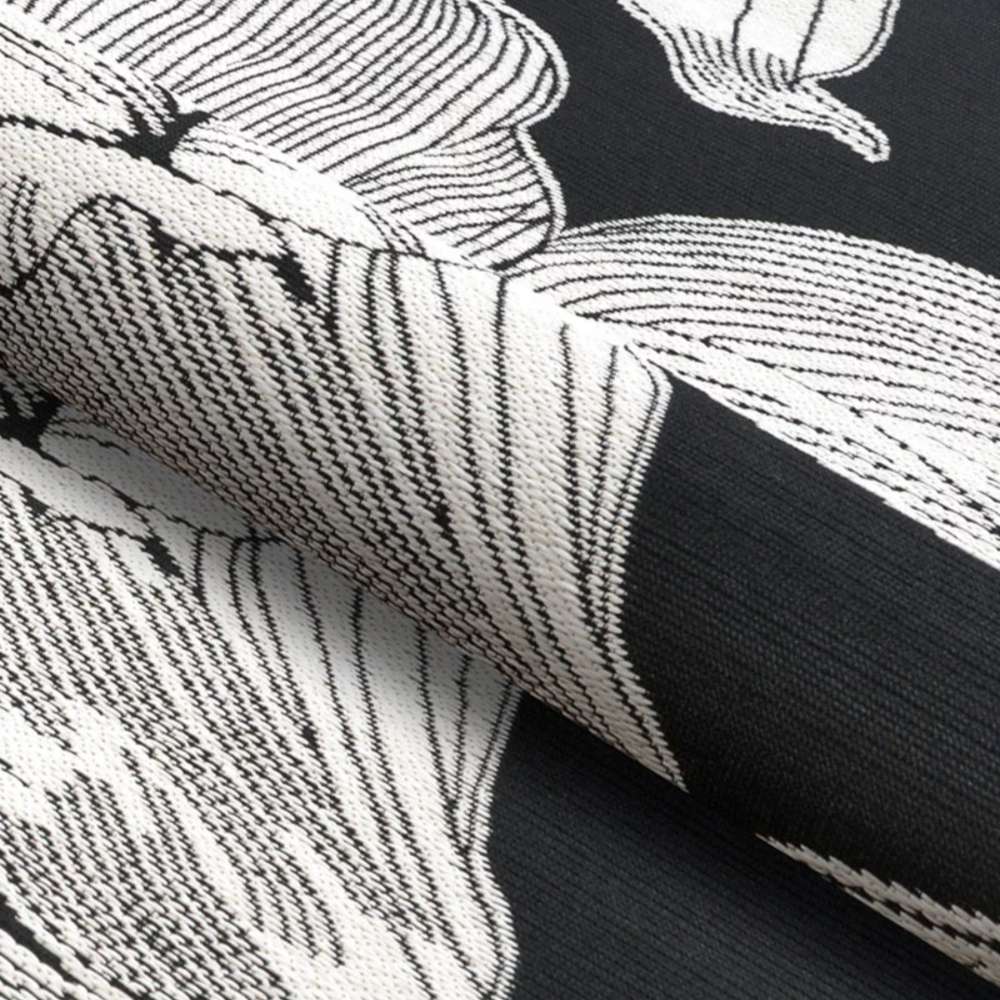 Folded portion of Couristan Dolce Indoor/Outdoor Rug - Flora/Nero highlights the thick woven texture and intricate cream flower detailing on the black surface