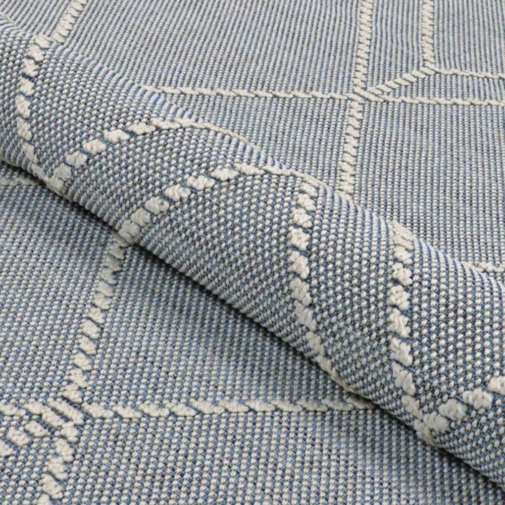 Folded view of Couristan Liguria Indoor/Outdoor Rug - Noli/Azul emphasizes its flexible material and raised geometric patterns