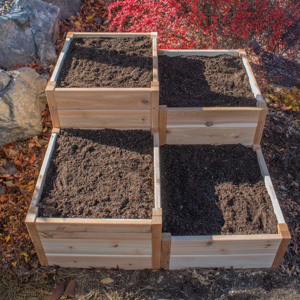 Four soil-filled sections in a corner layout highlight the Outdoor Living Today 3.5×4 Tiered Cedar Corner Raised Garden Bed in the middle