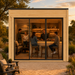Rectangular light wood studio with glass sliding doors, featuring a lit interior bar where four people gather at sunset.