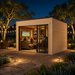 Rectangular wood studio with glass sliding doors at night, showing people inside a lit room with a television.