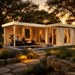 L-shaped light wood studio with glass doors, outdoor seating, and a small pool at sunset. Luisa 70 Freedom Office.