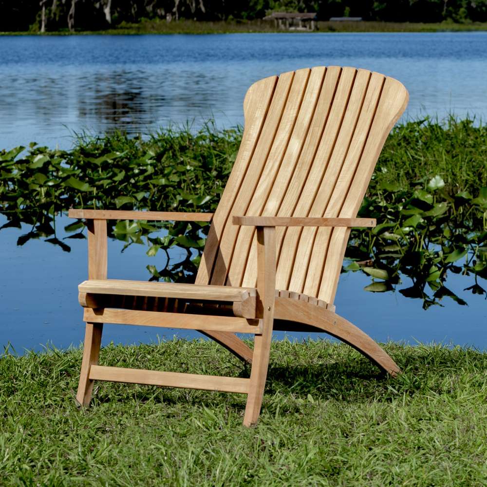 Front angled view of Westminster Teak Adirondack Lounger and Ottoman showing the tall slatted back, wide arms, and sturdy curved teak legs