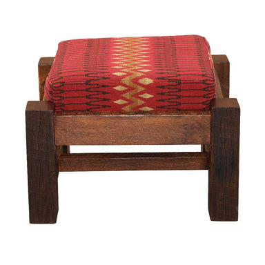 Front view of Fireside Lodge Barnwood Ottoman featuring its red geometric cushion sitting atop chunky, weathered wooden legs