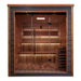 Front view of Golden Designs Bergen 6 Person Outdoor-Indoor Traditional Sauna showing a dark exterior, glass front, lit cedar benches and a guarded stove