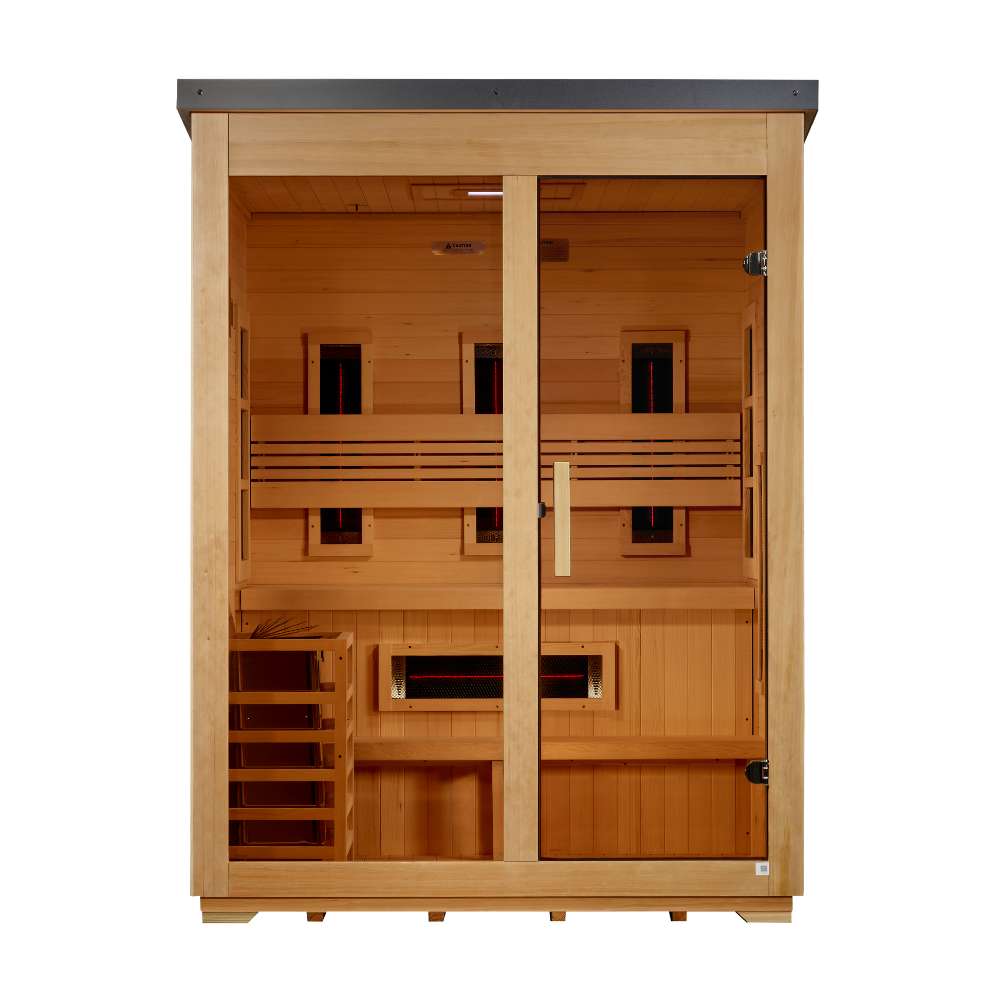 Front view of Golden Designs Carinthia 3 Person Hybrid Flat Roof Outdoor Sauna showing a black flat roof, hemlock frame, glass front, carbon panels and a guarded stove