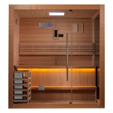 Front view of Golden Designs Forssa 3-4 Person Traditional Sauna showing a wide glass front, a stove behind a wooden guard on the left and amber light under the bench