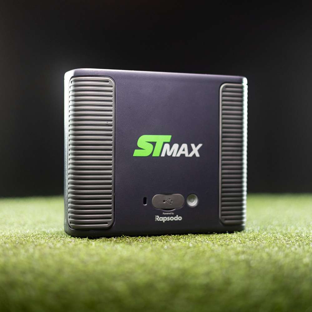 Front view of SKYTRAK ST MAX Launch Monitor standing on green artificial turf against a dark background