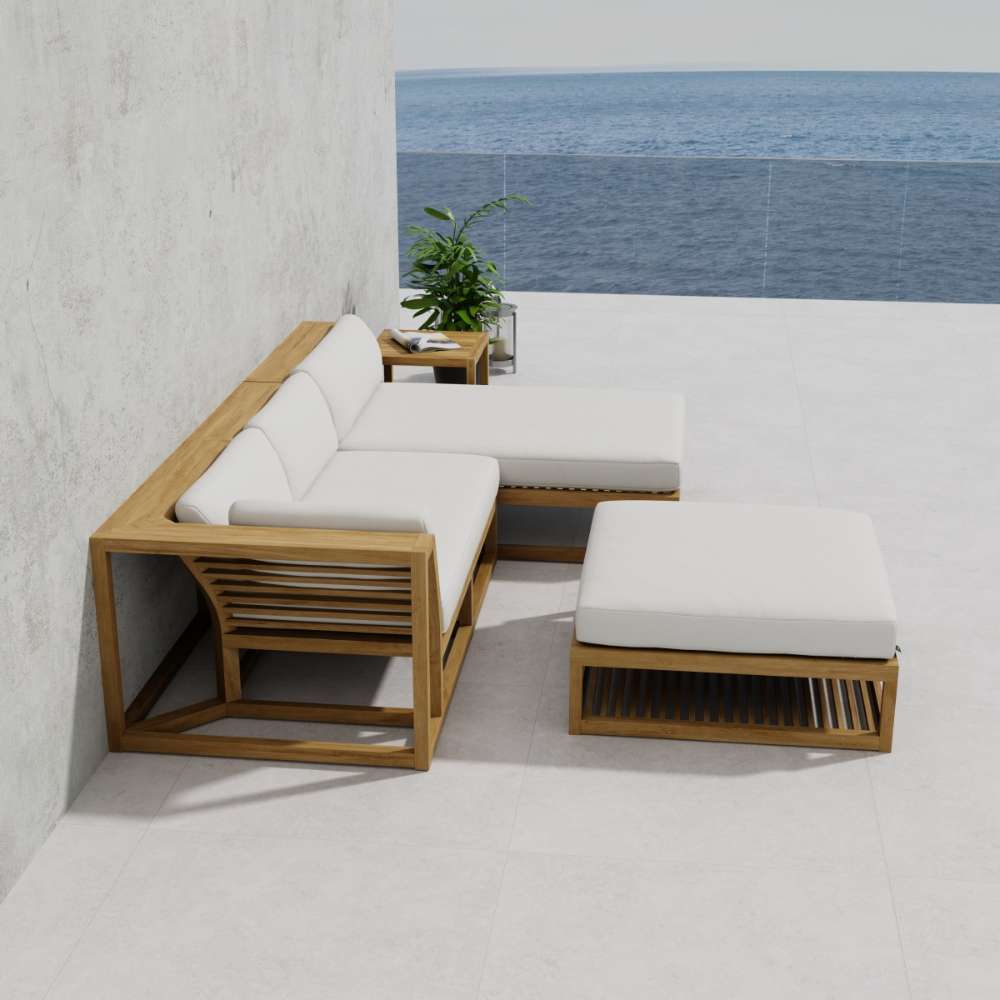 Full patio arrangement of Westminster Teak Maya 4pc Lounge Set, including sectional seating, chaise, ottoman, and tables, placed against a wall with an ocean view in the background
