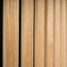 GIK Acoustics SlatFusor™ Corner Bass Trap shown in a detailed close-up highlighting vertical natural wood slats mounted over an acoustic backing