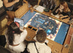 Game Theory Tables The Arena Founders Edition provides a top-down view of a fantasy dungeon setup, with players fully engaged in the game