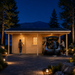 Brightly illuminated Garage Bjarne 44 at night near Lake Tahoe as adults arrive home and unload a vehicle beneath the carport.