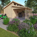 GardenHouse24 USA Garage Morten 44A Garden Room in a garden setting with a grill under the open carport