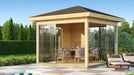 GardenHouse24 USA Glaspavillon ALU 44E ISO Garden Room features a stylish dining setup inside a sunlit glass pavilion near lounge chairs