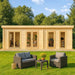 GardenHouse24 USA Henning 70 Garden Room with multiple glass doors and cozy interior spaces stands in a lush green yard