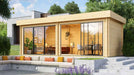 GardenHouse24 USA Lasse 44A ALU Garden Room is set up in a landscaped garden with furniture inside, appearing as a stylish home office or lounge