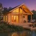 GardenHouse24 USA Sauna Marit 90 Garden Room at sunset, glowing warmly from within