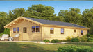 GardenHouse24 USA Sean 44 Garden Room is shown in a wide-angle view from the front left corner, highlighting its long rectangular design, wooden cladding, multiple windows, and a black metal roof surrounded by gre