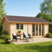 GardenHouse24 USA Skive 70 Garden Room is shown with soft light wood, symmetrical windows, and two black wicker chairs on a gravel patio