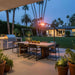 Glowing Outdoor Order Curve Infrared Heater provides warmth over an outdoor dining table beside a built-in grill