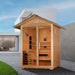 Golden Designs Carinthia 3 Person Hybrid Outdoor Sauna on a gravel patio beside a lawn in front of a modern white building