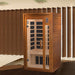 Golden Designs Dynamic Barcelona Elite 1-2 Person Ultra Low EMF Far Infrared Sauna stands in a room with tall wood slat walls and a dark wood floor