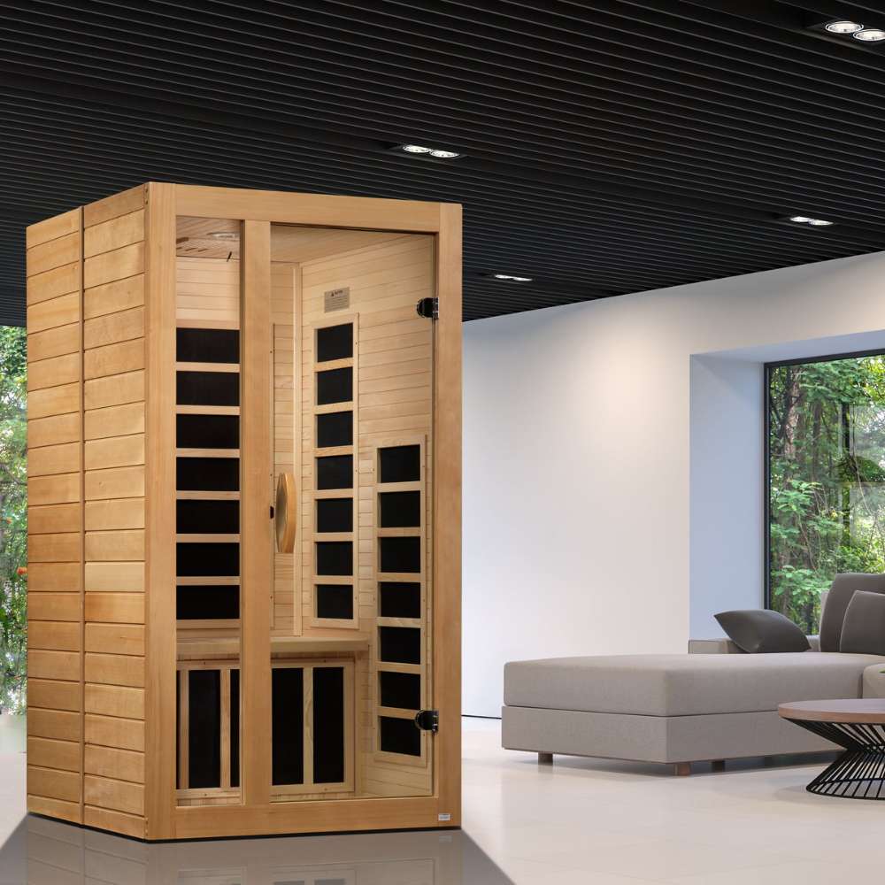 Golden Designs Dynamic Gracia 1-2 Person Low EMF Far Infrared Sauna stands in a modern living room beside a gray sofa and large windows