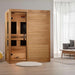 Golden Designs Dynamic Toscana 3 Person Low EMF Far Infrared Sauna stands in a bright living room with a round rug and armchair
