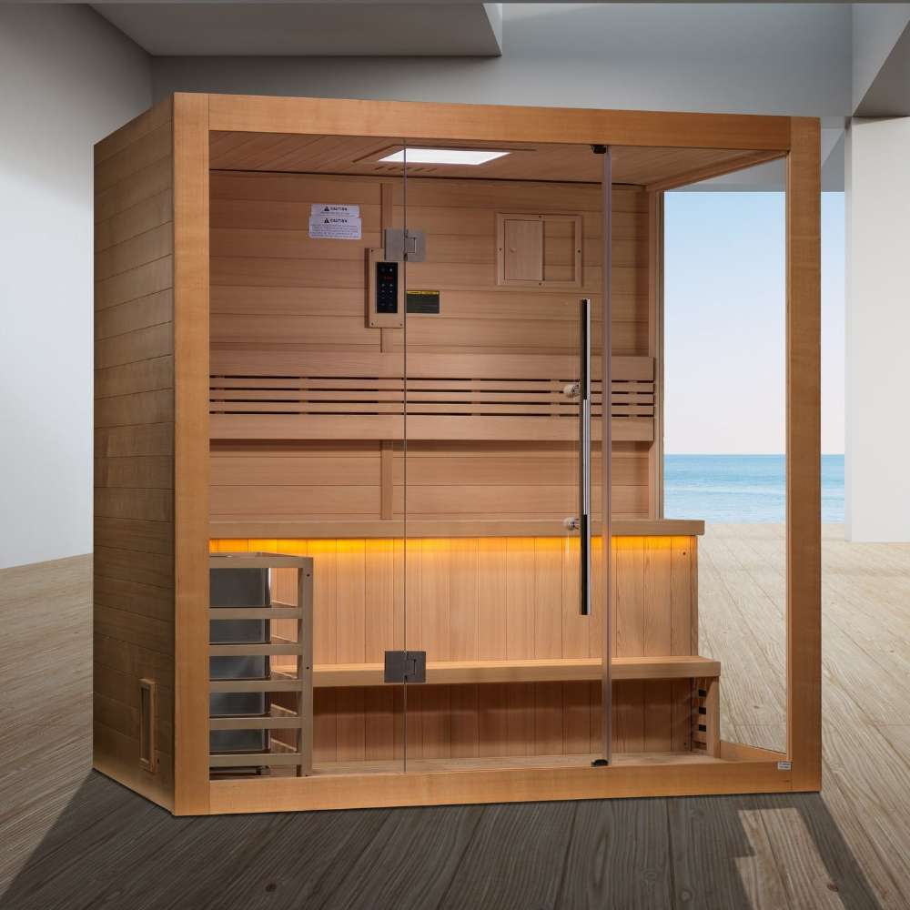 Golden Designs Forssa 3-4 Person Traditional Sauna stands on a wood floor in a bright room with a gray wall and a window overlooking the sea