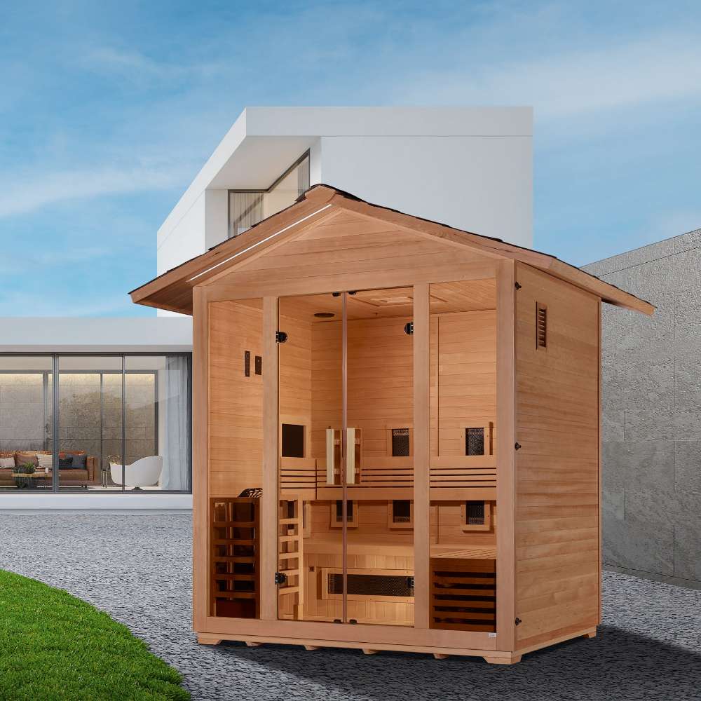 Golden Designs Gargellen 5 Person Hybrid Outdoor Sauna on a gravel yard beside a lawn in front of a modern white house