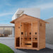 Golden Designs Gargellen 5 Person Hybrid Outdoor Sauna on a gravel yard beside a lawn in front of a modern white house