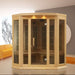 Golden Designs Maxxus 3 Person Low EMF Far Infrared Corner Sauna in Hemlock fills the corner of a modern room beside an orange sofa