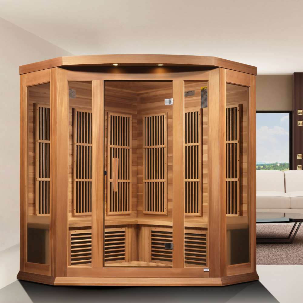 Golden Designs Maxxus 3 Person Low EMF Far Infrared Corner Sauna in Red Cedar stands in a bright living room with large windows and a white sofa