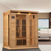 Golden Designs Maxxus 3 Person Near Zero EMF Far Infrared Sauna in Hemlock stands in a bright room with tall windows and a white sofa