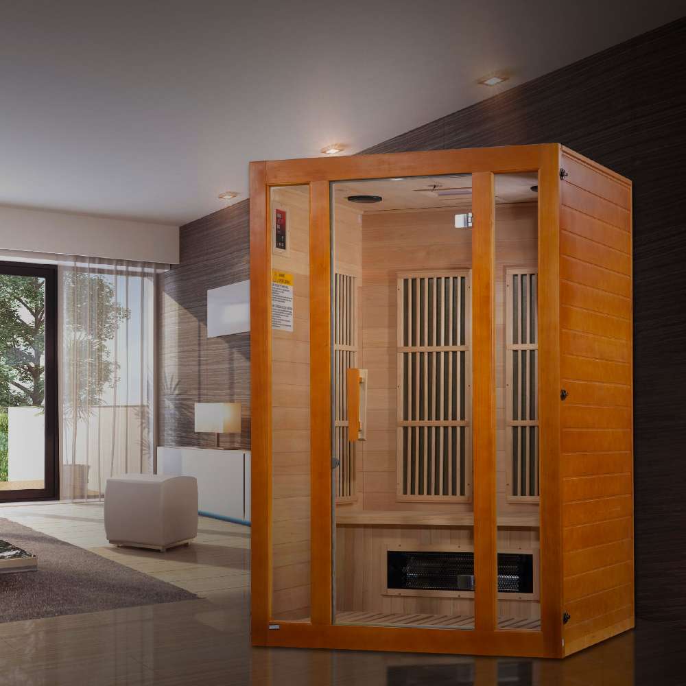 Golden Designs Maxxus Aspen Dual Tech 2 Person Low EMF Far Infrared Sauna stands in a modern living room with tall windows and a white ottoman